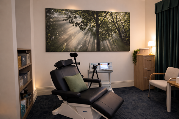 Perth Clinic rTMS treatment room with a reclining treatment chair and TMS equipment